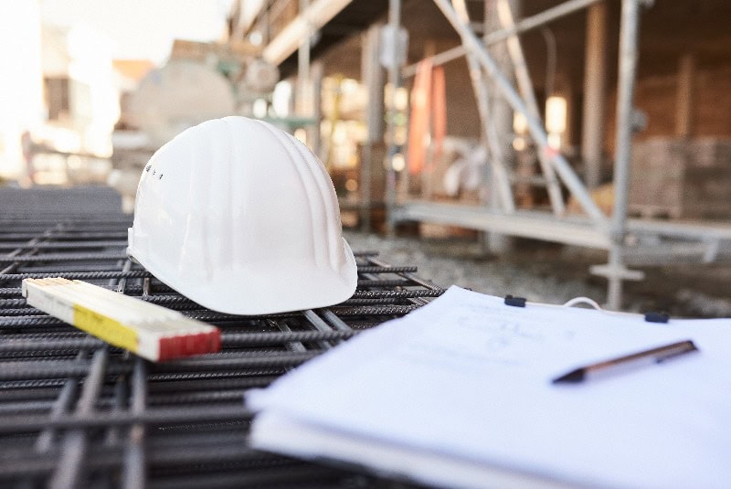 weißer Baustellen Helm, Zollstab, Klemmbrett auf der Baustelle